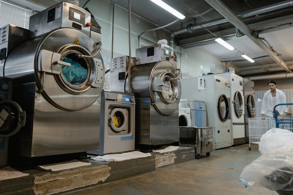 Crafting Captivating Headlines: Your awesome post title goes here Industrial laundromat interior with large washing machines and a man pushing a trolley.